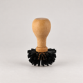 Wooden coffee cleaning brush with black bristles — warm grey background