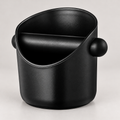 Compact black espresso knock box with rubber knock bar — warm grey background