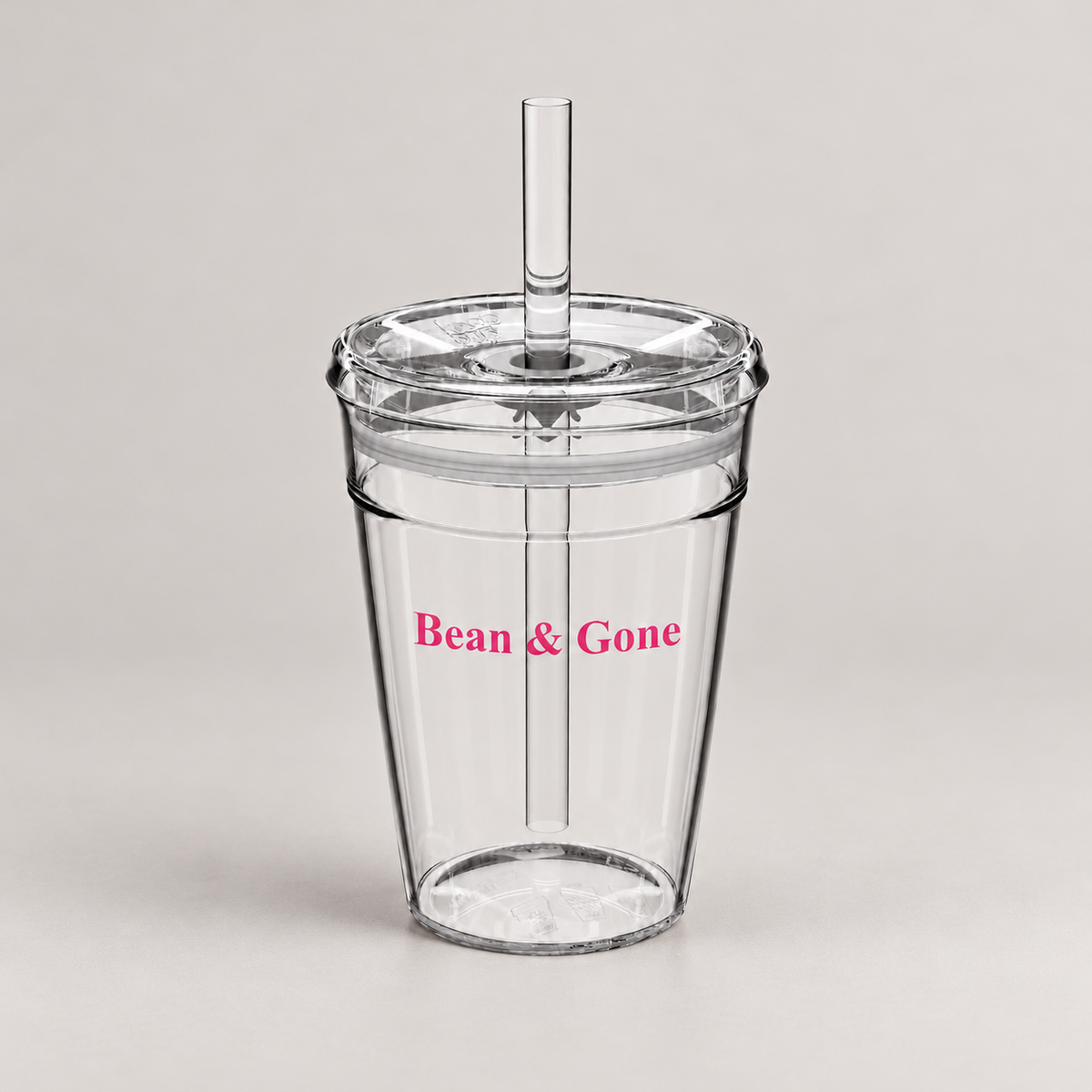 Bean & Gone Reusable Iced Coffee Cup — Pink 12oz with Hard Plastic Straw on a warm grey background